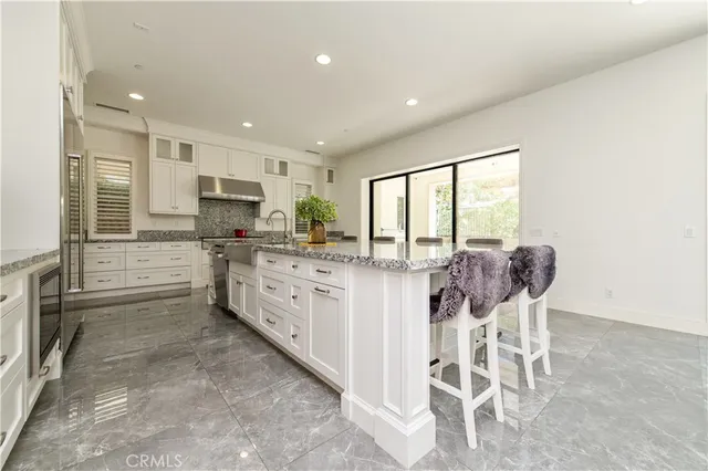 a kitchen with stainless steel appliances granite countertop a sink stove and cabinets