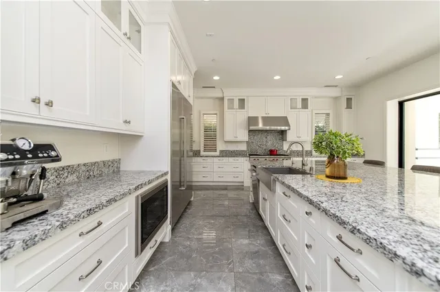 a large white kitchen with a large window and a sink