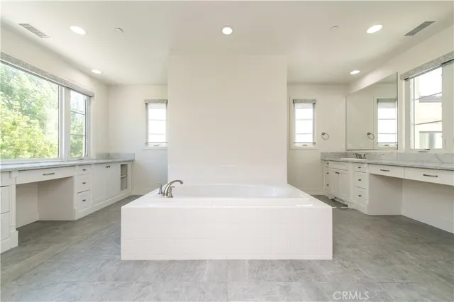 a large white bathroom with a large tub sink and vanity
