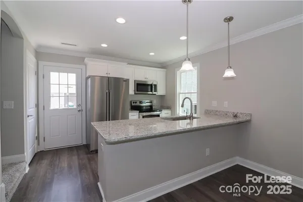 a kitchen with kitchen island a sink stainless steel appliances and window