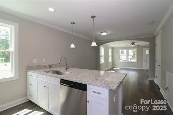 a open kitchen with kitchen island a sink granite counter tops and a window