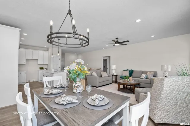 a view of a dining room with furniture a chandelier and wooden floor
