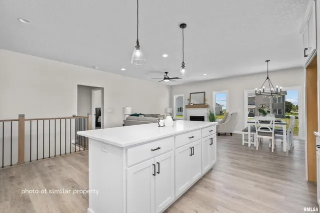 a large white kitchen with a large island oven a sink stainless steel appliances and cabinets