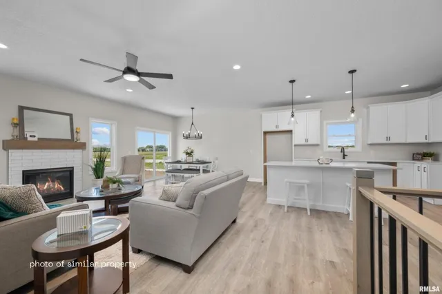 a large living room with stainless steel appliances kitchen island granite countertop furniture and a fireplace