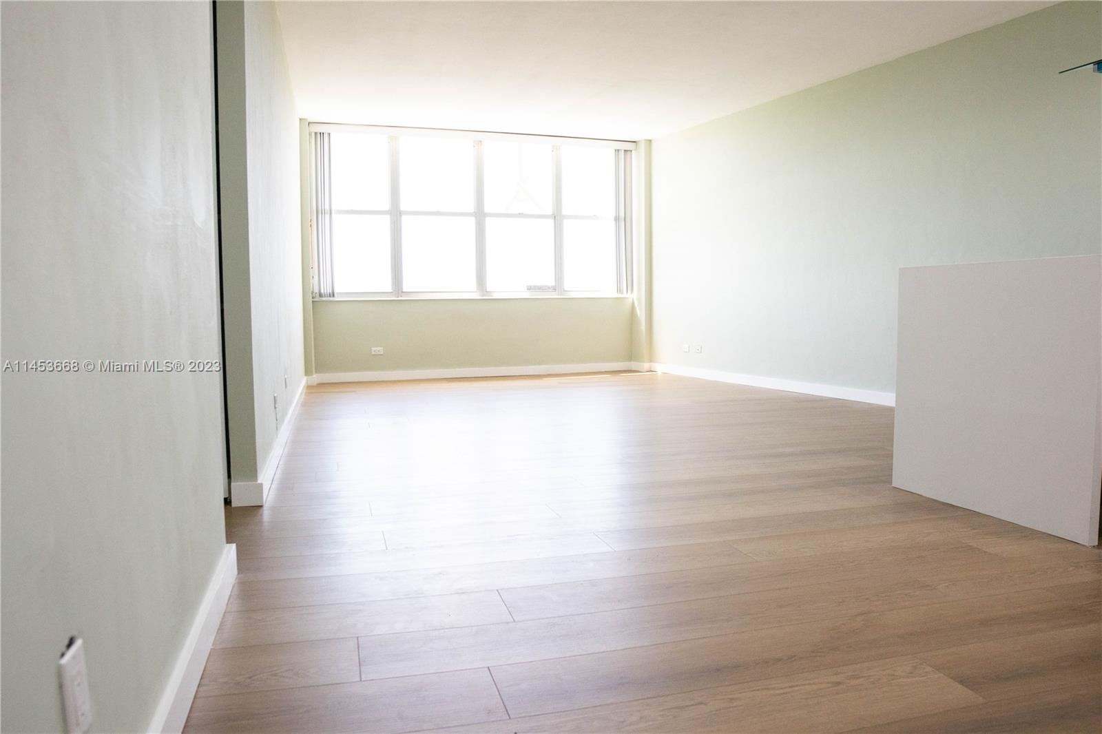 North Beach Miami Beach, FL 33141 - Photo 2 of 30 an empty room with wooden floor and windows