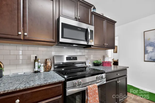 a kitchen with stainless steel appliances granite countertop a sink stove and cabinets