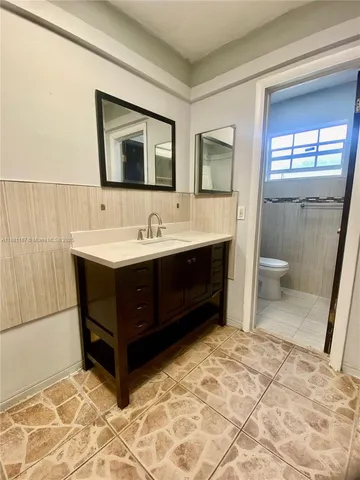 a bathroom with a sink a toilet and mirror