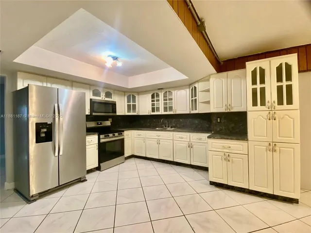 a kitchen with stainless steel appliances granite countertop a refrigerator and a stove top oven