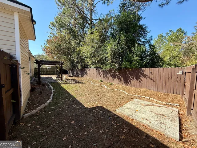 a view of a yard with wooden fence