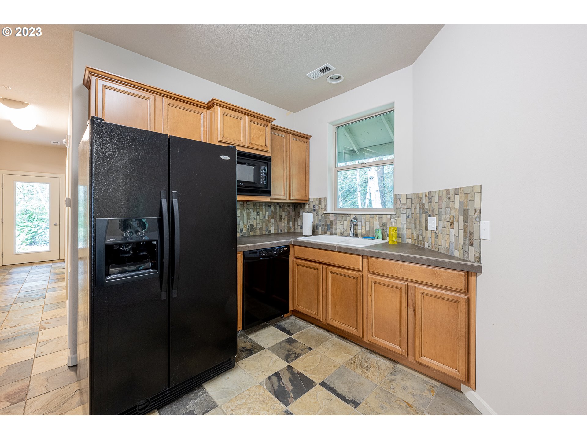 17335 Ruben Lane, Unit 19 Sandy, OR 97055 - Photo 25 of 27 a kitchen with granite countertop stainless steel appliances a refrigerator and a sink