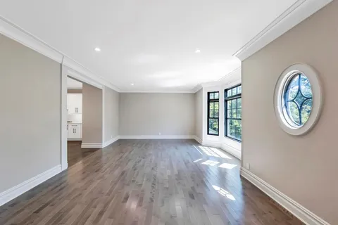 an empty room with wooden floor and window