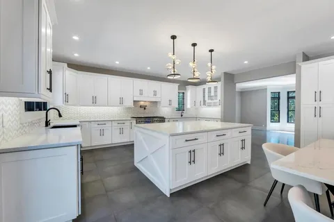 a kitchen with stainless steel appliances kitchen island granite countertop a sink and cabinets