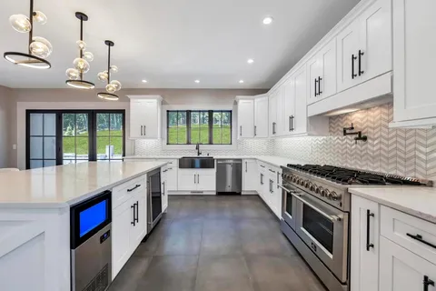 a large kitchen with stainless steel appliances granite countertop a stove and a sink