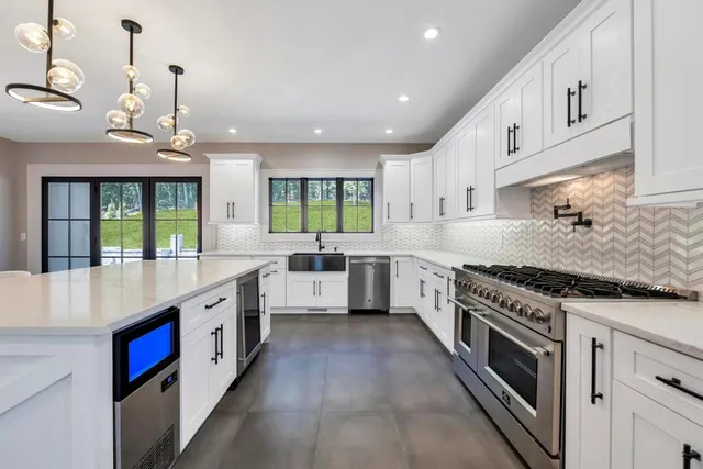 a large kitchen with stainless steel appliances granite countertop a stove and a sink