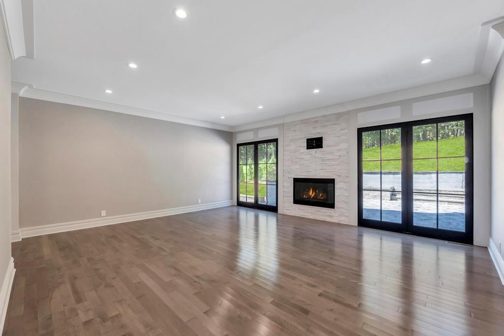 589 Old Bridge Road Northport, NY 11768 - Photo 23 of 40 an empty room with wooden floor fireplace and windows