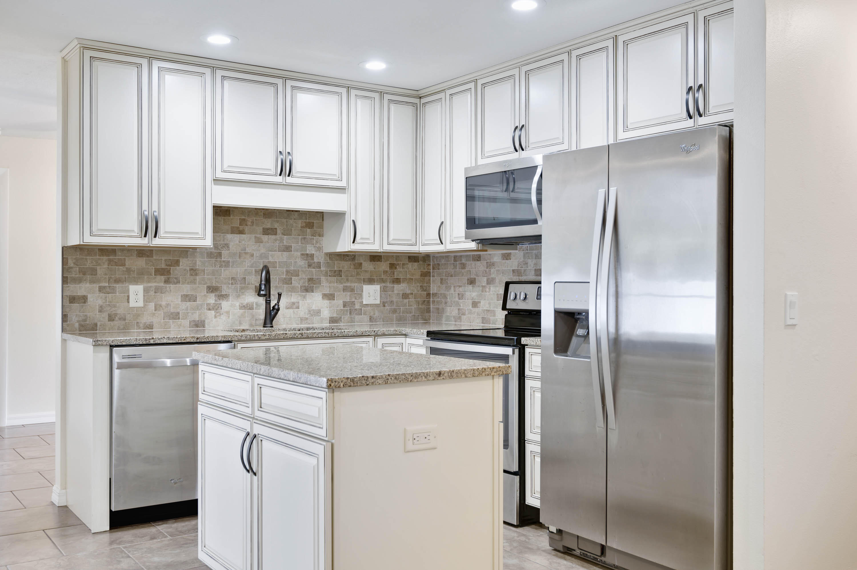 2331 Scotland Road Cocoa, FL 32926 - Photo 4 of 20 a kitchen with stainless steel appliances granite countertop a refrigerator a stove and white cabinets
