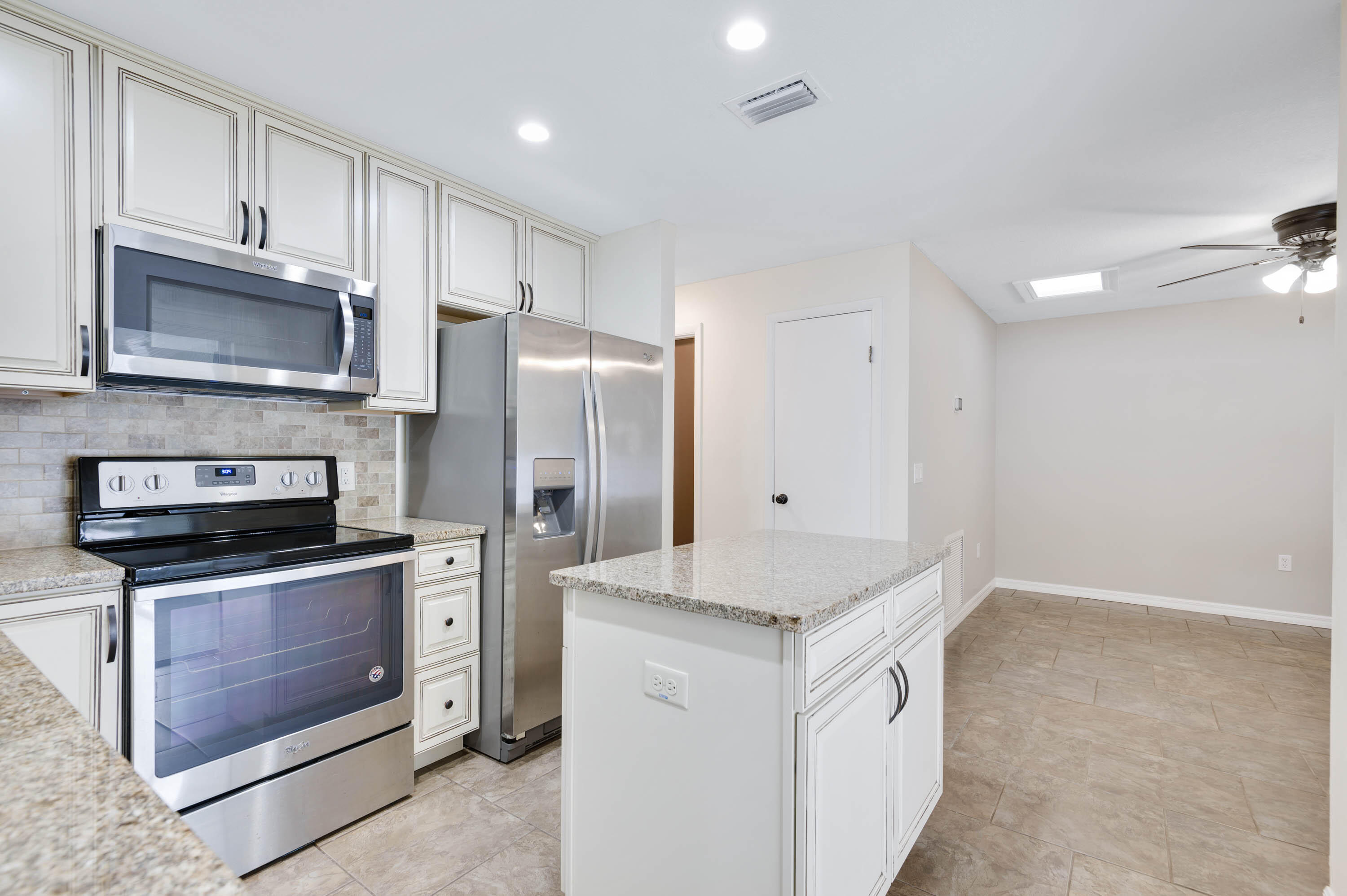 2331 Scotland Road Cocoa, FL 32926 - Photo 5 of 20 a kitchen with granite countertop a refrigerator stove and microwave