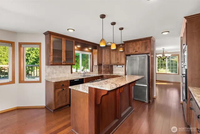 a kitchen with stainless steel appliances granite countertop wooden floors and sink