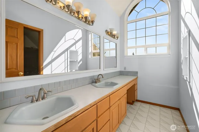 a bathroom with double sink and a window