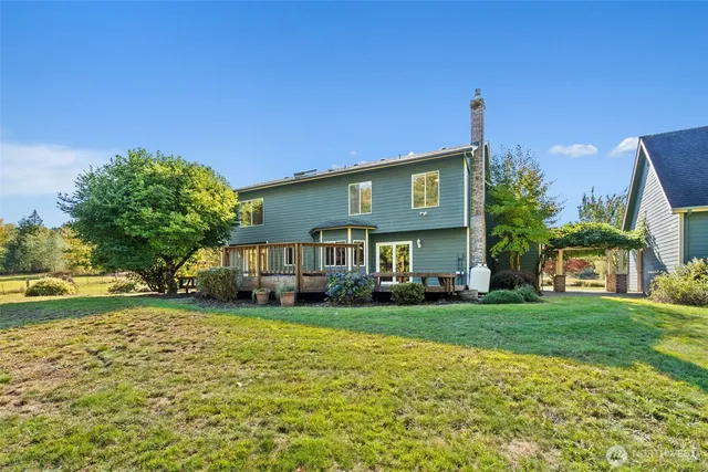 a view of a house with a big yard and large trees