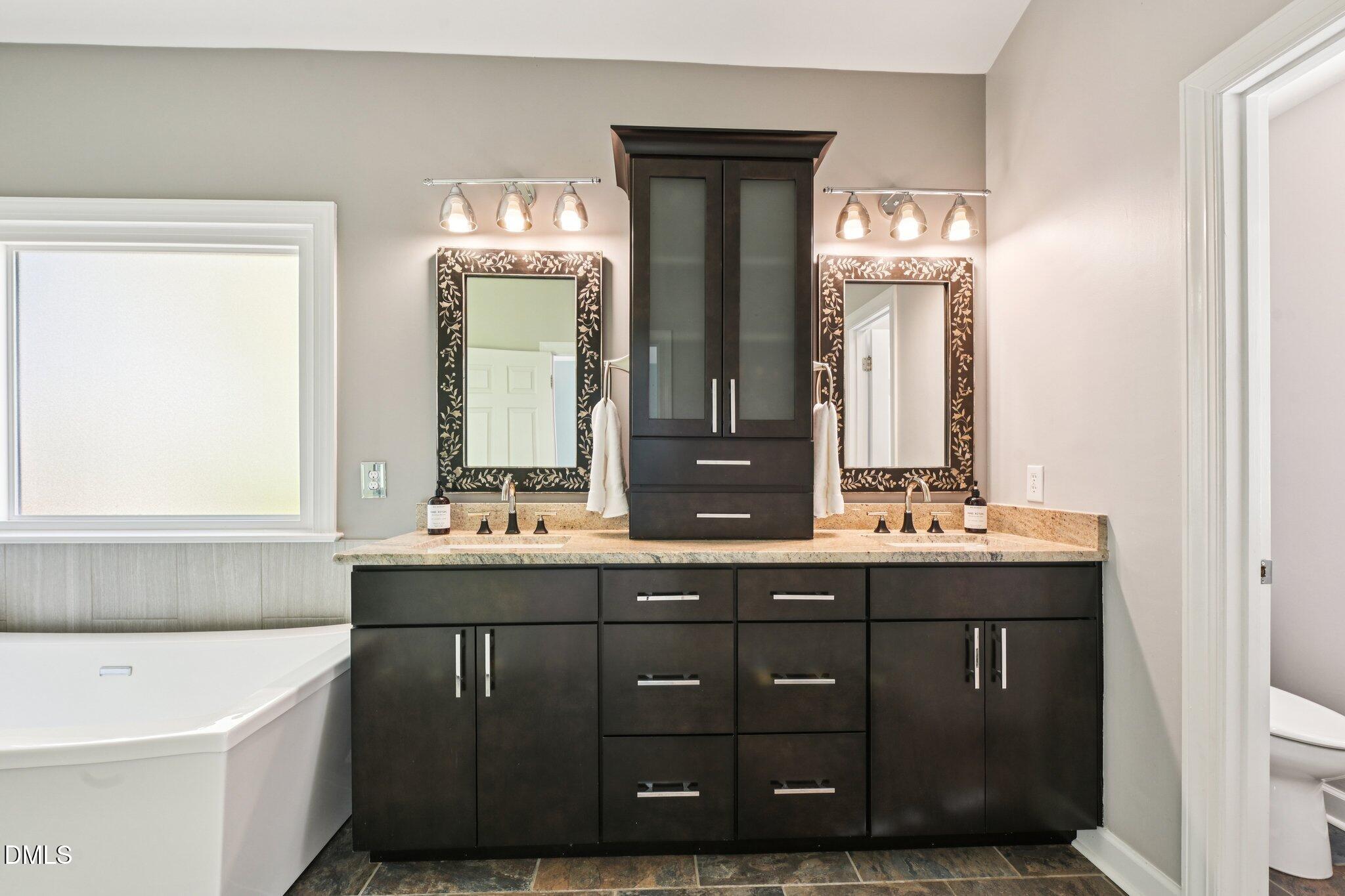 3008 Walton Heath Court Raleigh, NC 27612 - Photo 30 of 57 a bathroom with a double vanity sink and a bathtub