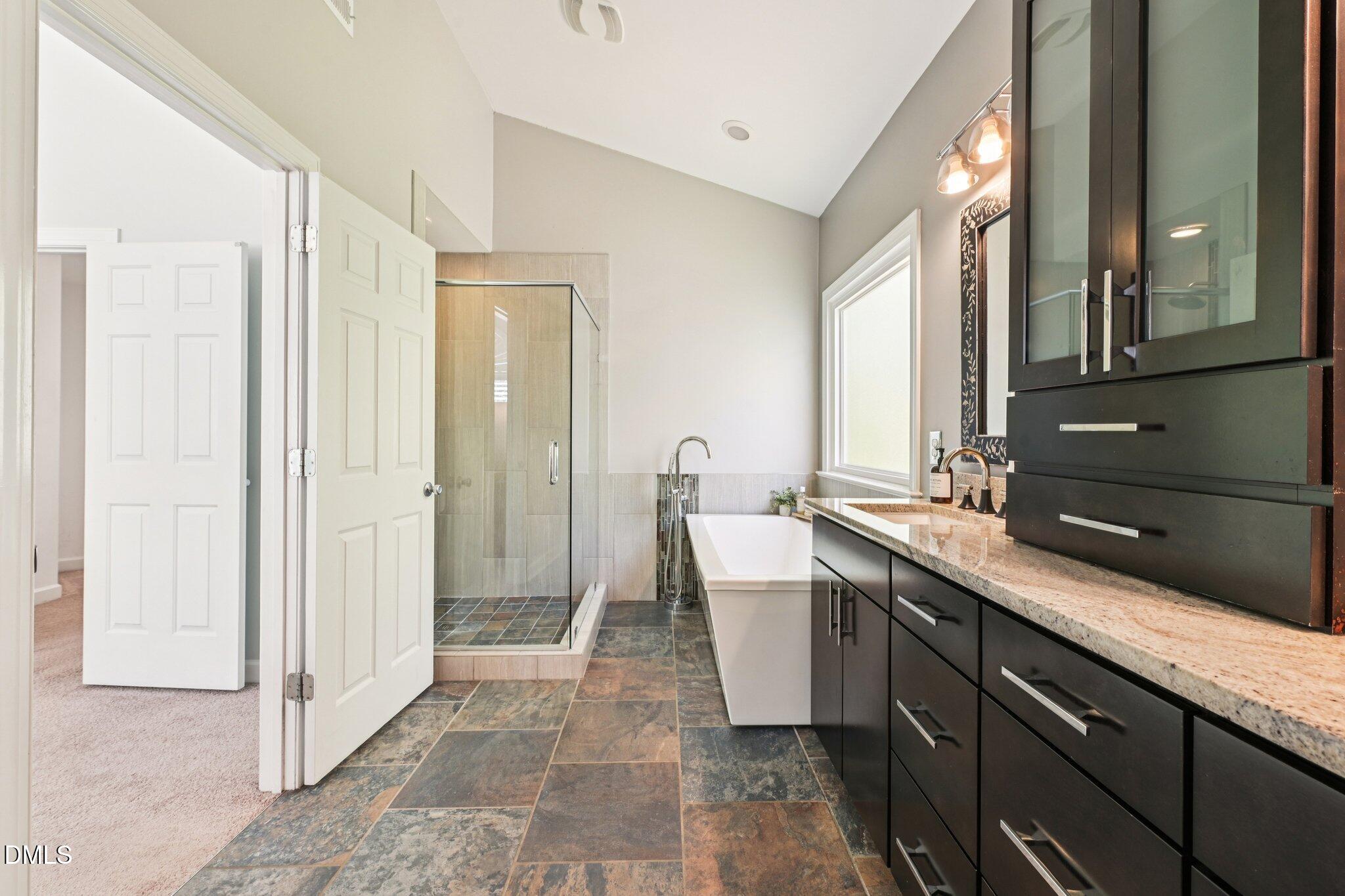 3008 Walton Heath Court Raleigh, NC 27612 - Photo 33 of 57 a spacious bathroom with a bathtub sink and mirror