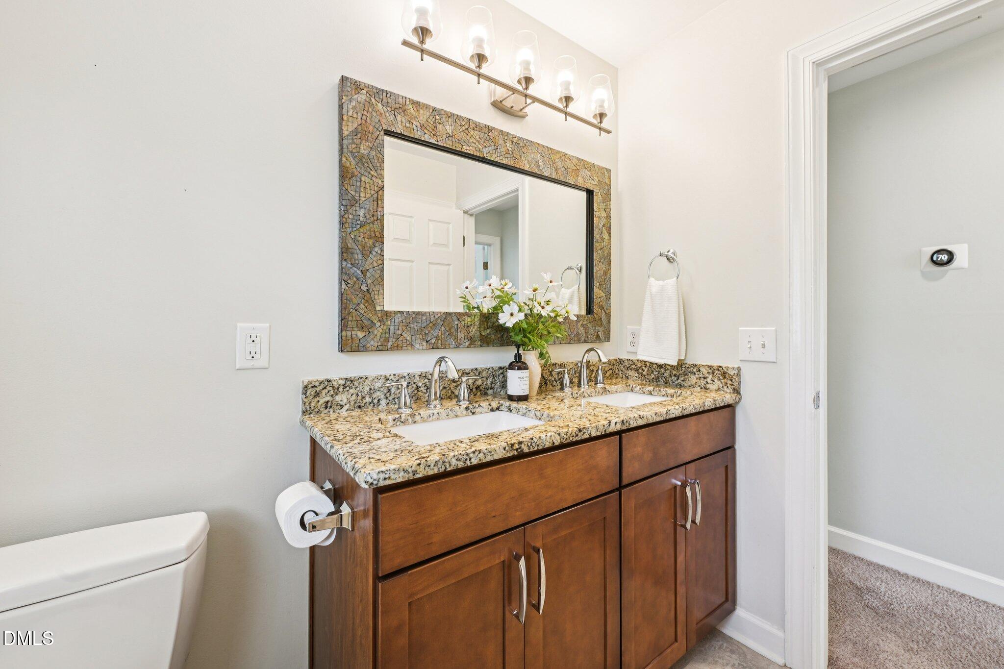 3008 Walton Heath Court Raleigh, NC 27612 - Photo 43 of 57 a bathroom with a granite countertop sink a toilet and a mirror
