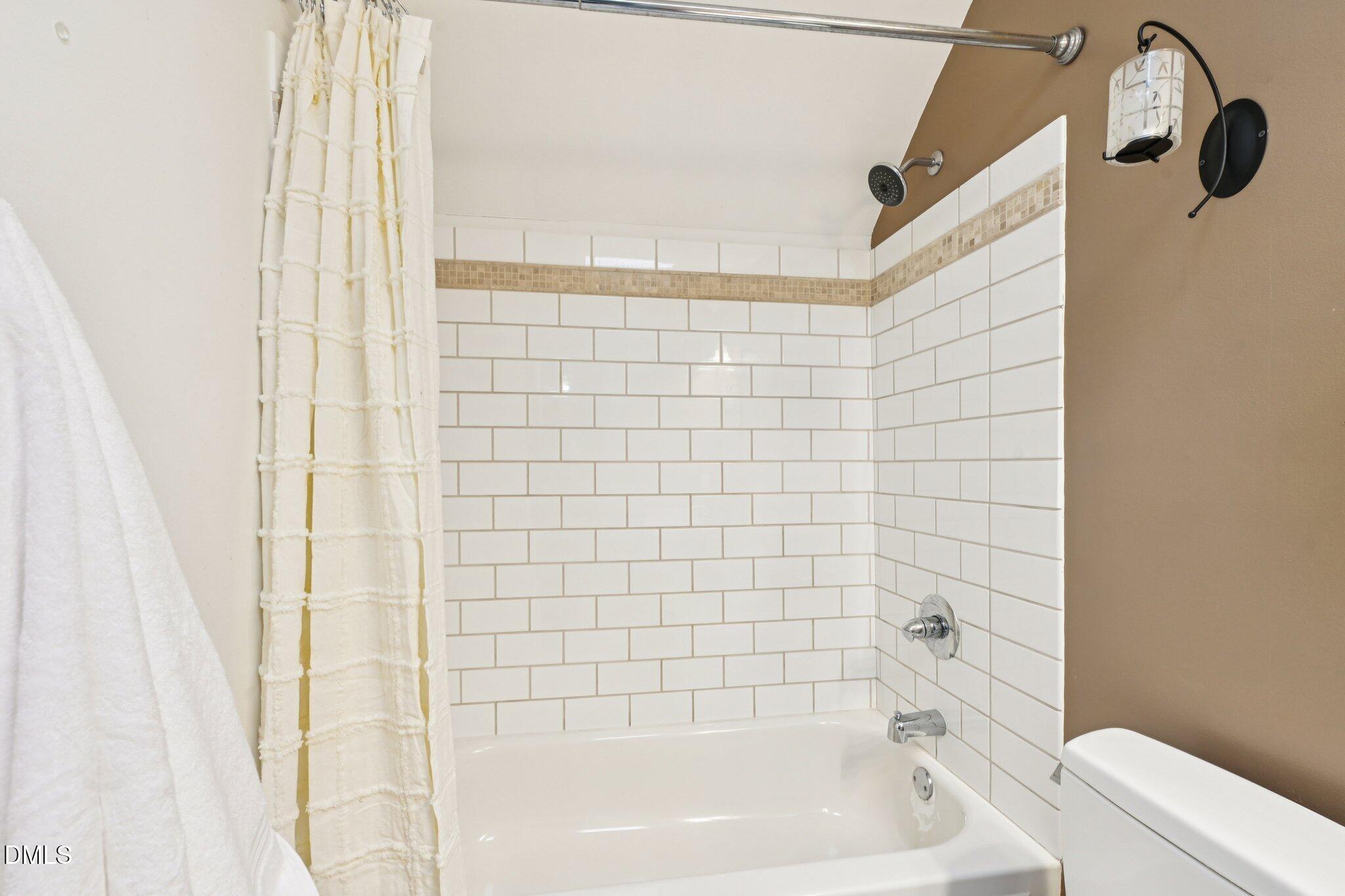 3008 Walton Heath Court Raleigh, NC 27612 - Photo 46 of 57 a bathroom with a shower and a bathtub