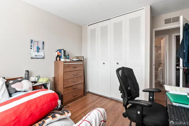 a bed room with a bed and a wooden floor