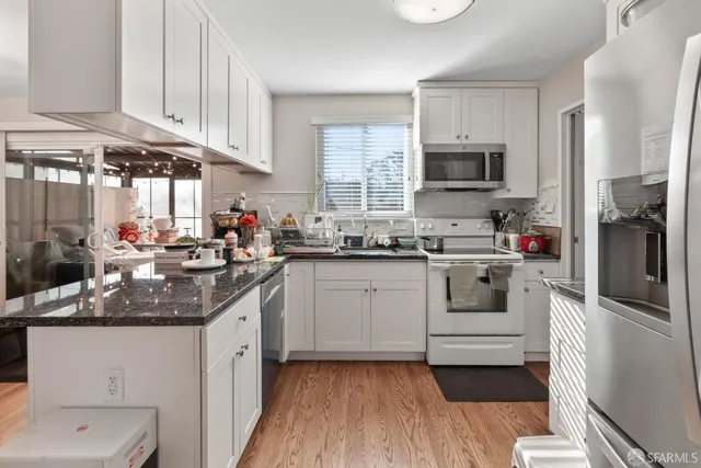 a kitchen with stainless steel appliances granite countertop a stove a refrigerator and a sink