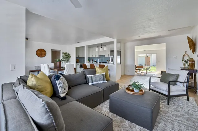 a kitchen with stainless steel appliances a dining table chairs stove refrigerator and cabinets