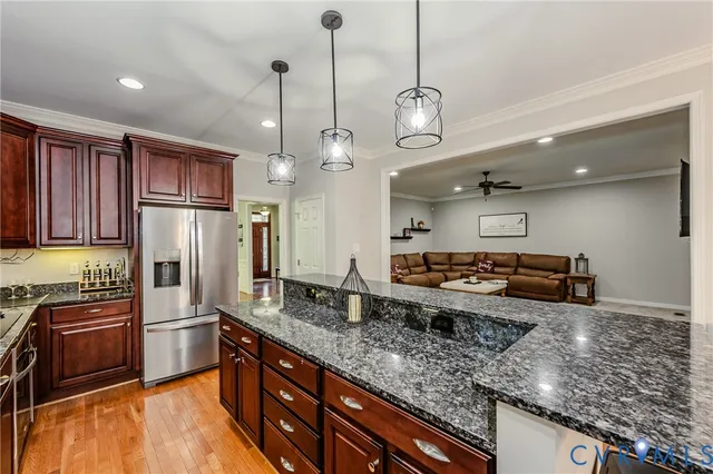 a kitchen with stainless steel appliances granite countertop a sink a stove and a refrigerator