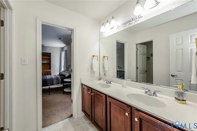 a en suite bathroom with a sink double vanity and a mirror