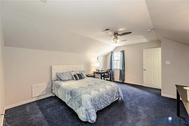a spacious bedroom with a bed and a ceiling fan