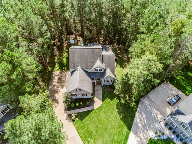 an aerial view of a house with a garden and trees