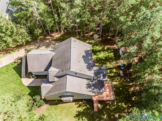 an aerial view of a house with a yard and trees
