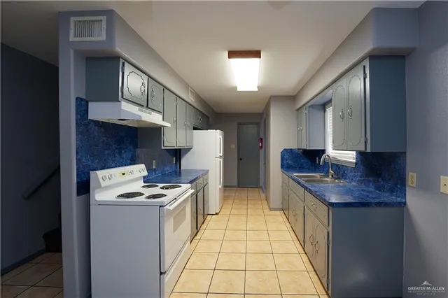 a kitchen with granite countertop a sink and a stove