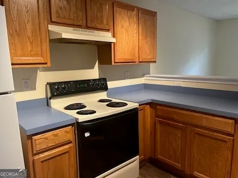 a kitchen with wooden cabinets stove and sink