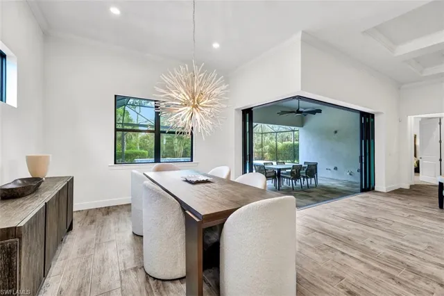 a kitchen with stainless steel appliances granite countertop a stove a sink a refrigerator and a dining table with chairs