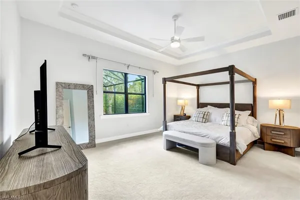 a spacious bedroom with a large bed and a flat tv screen on dresser