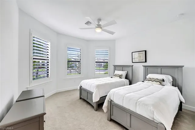 a spacious bedroom with two beds and a window