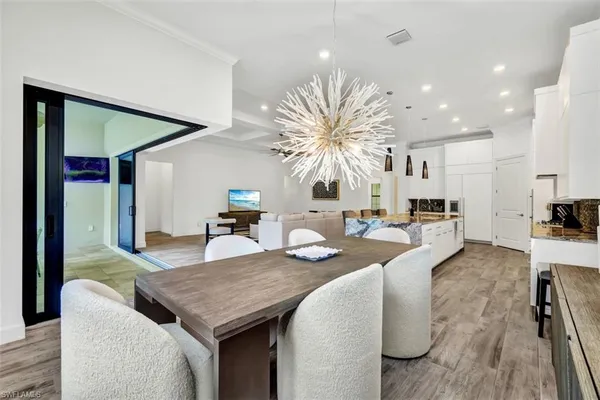 a living room with furniture kitchen view and a large window