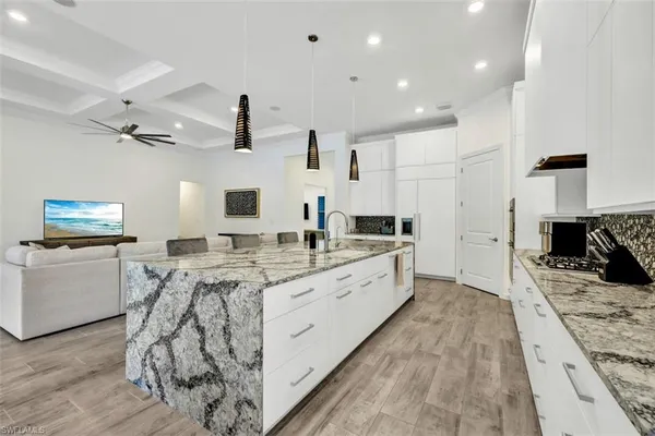 a large kitchen with stainless steel appliances kitchen island granite countertop a sink and cabinets