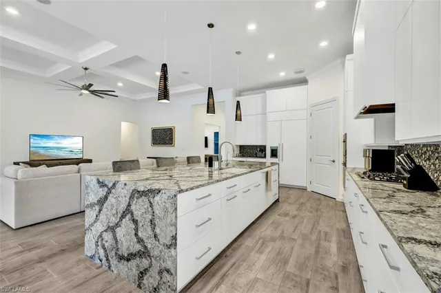 a large kitchen with stainless steel appliances kitchen island granite countertop a sink and cabinets