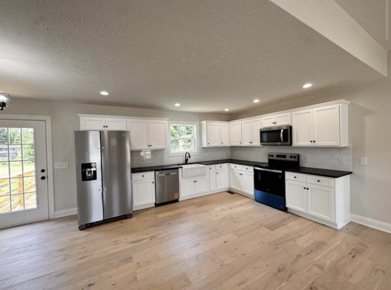 2105 Maple Grove Road Cadiz, KY 42211 - Photo 5 of 13 a large kitchen with stainless steel appliances granite countertop a large counter top and wooden floors