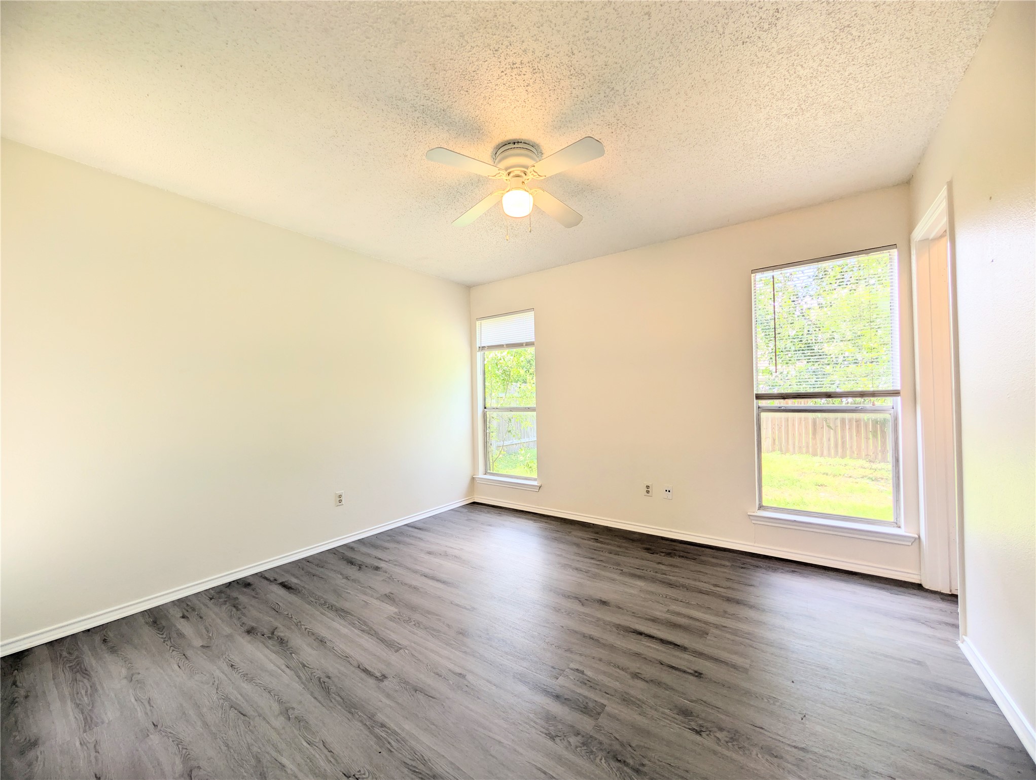 2036 Redwing Way Round Rock, TX 78664 - Photo 16 of 23 Primary Bedroom
A quiet space with rich wood-look flooring, two bright windows, and a ceiling fan for comfort.