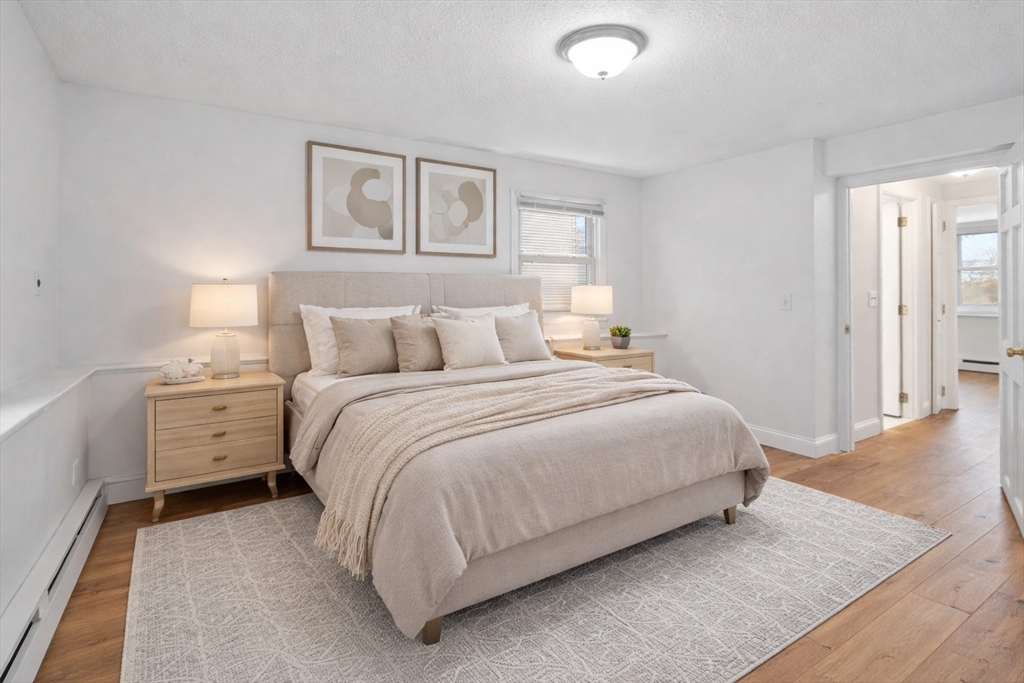 121 Cambridge Road, Unit 2 Woburn, MA 01801 - Photo 10 of 23 a bedroom with a bed and a night stand