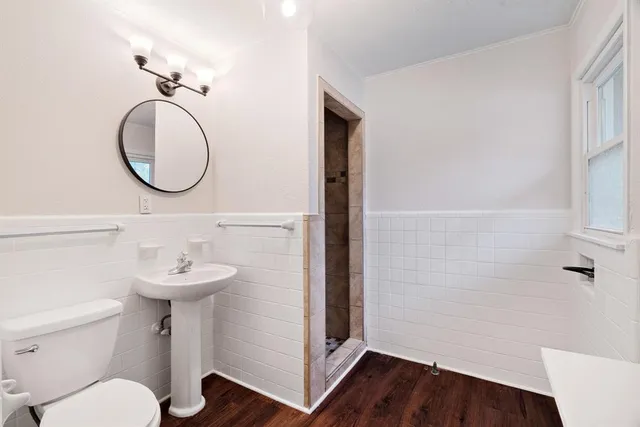 a bathroom with a sink a toilet and a mirror