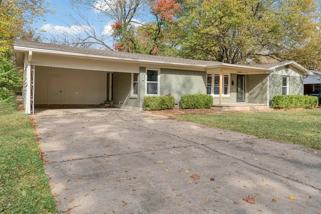 a front view of a house with a garden and yard