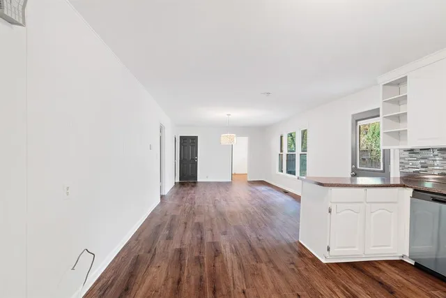 a view of a kitchen counter space with wooden floor and window